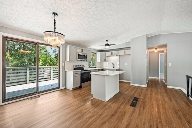 kitchen featuring gray cabinets, dark hardwood / wood-style flooring, stainless steel appliances, and hanging light fixtures