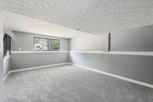 basement featuring carpet flooring and a textured ceiling