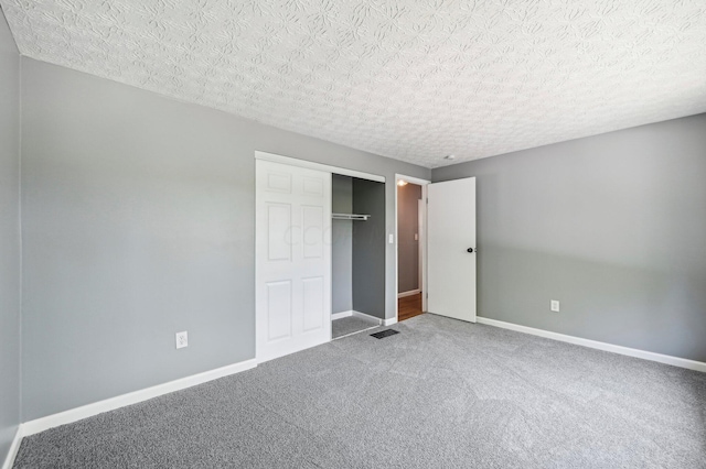 unfurnished bedroom featuring a closet, carpet, and a textured ceiling