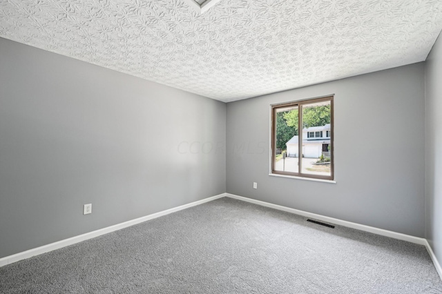 spare room featuring carpet floors and a textured ceiling