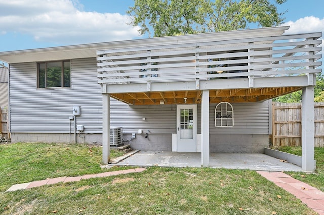 back of property featuring central AC, a deck, a patio area, and a lawn