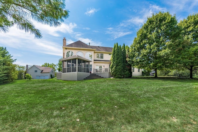 rear view of house featuring a yard and a sunroom