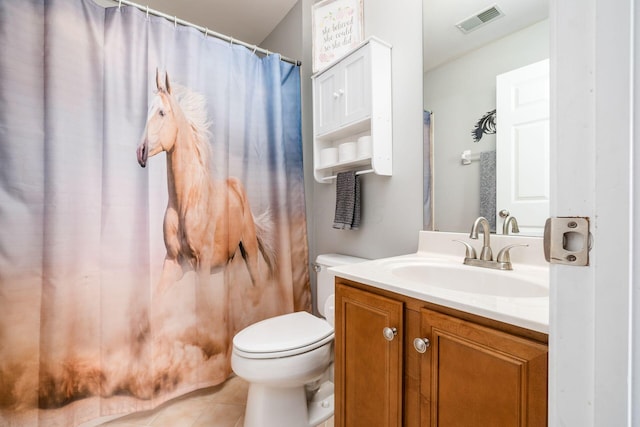 bathroom featuring tile patterned flooring, vanity, and toilet