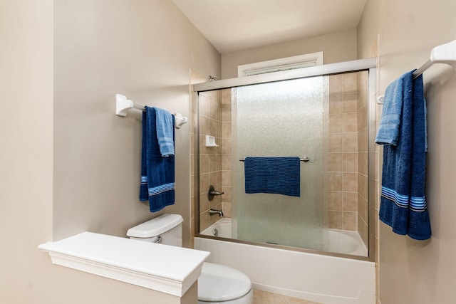 bathroom with tile patterned floors, toilet, and shower / bath combination with glass door