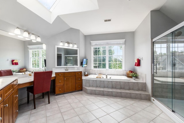 bathroom with tile patterned flooring, vanity, lofted ceiling with skylight, and plenty of natural light