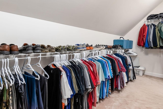 spacious closet featuring light colored carpet and lofted ceiling