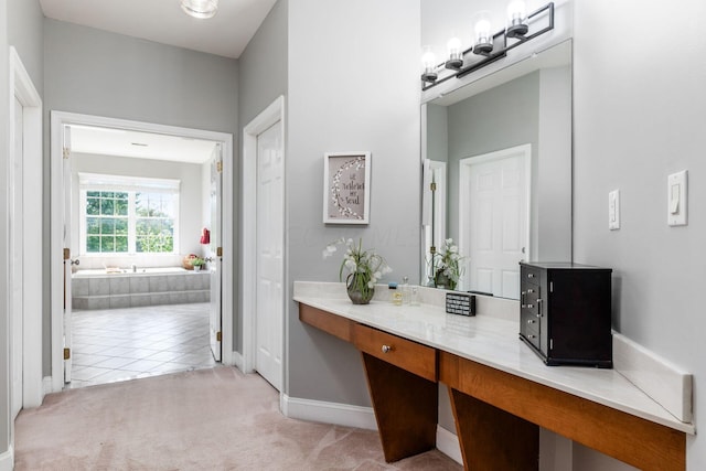 bathroom featuring vanity, tile patterned flooring, and a relaxing tiled tub