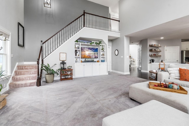 living room with carpet and a towering ceiling