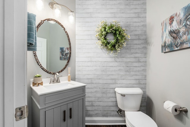 bathroom with hardwood / wood-style flooring, vanity, and toilet