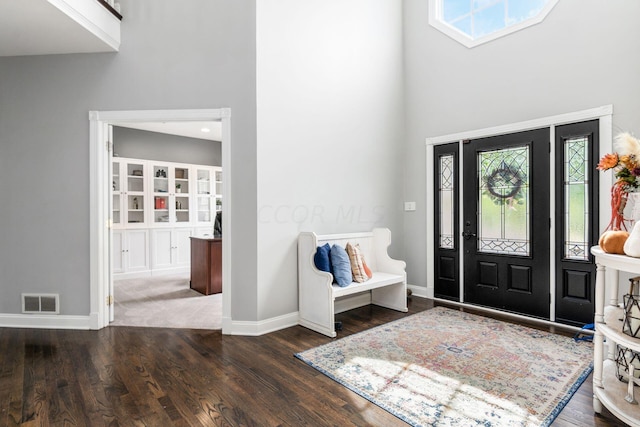 entryway with high vaulted ceiling and dark wood-type flooring