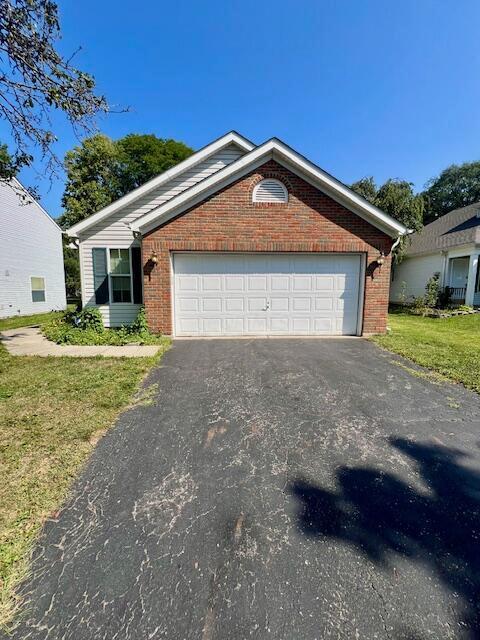 view of front of house with a garage and a front lawn