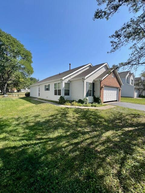 ranch-style home featuring a garage and a front lawn