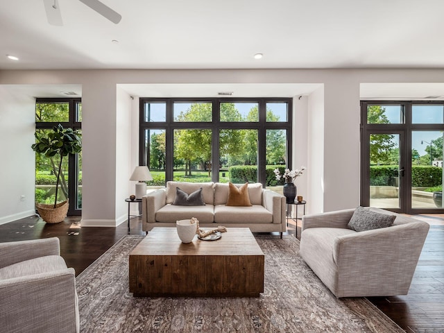 living room featuring plenty of natural light, dark wood-type flooring, and ceiling fan