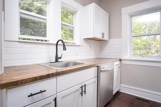 kitchen featuring butcher block countertops, dark hardwood / wood-style floors, white cabinets, and sink