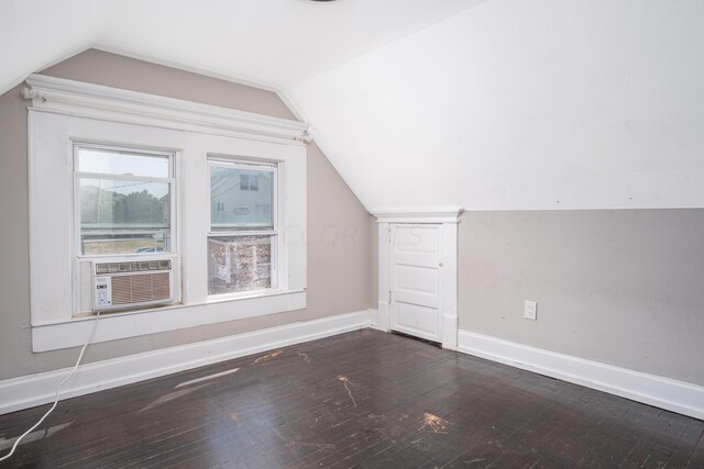 additional living space with dark hardwood / wood-style flooring, vaulted ceiling, and cooling unit