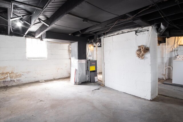 basement featuring washer / dryer and heating unit