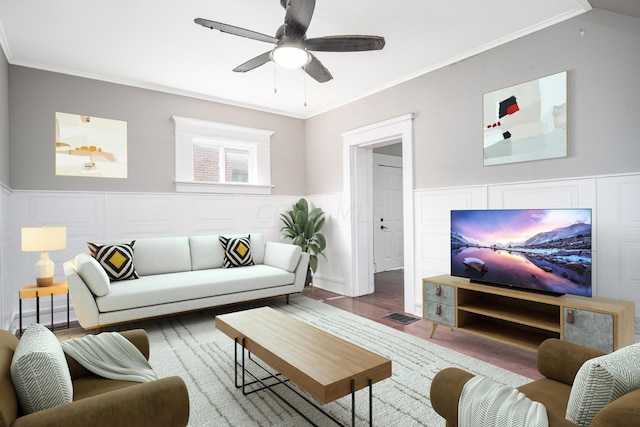 living room featuring hardwood / wood-style flooring, ceiling fan, and crown molding