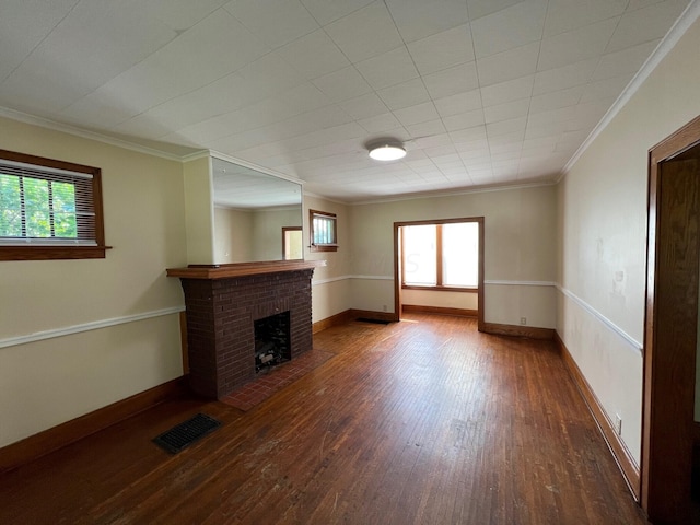 unfurnished living room with wood-type flooring, a brick fireplace, and crown molding