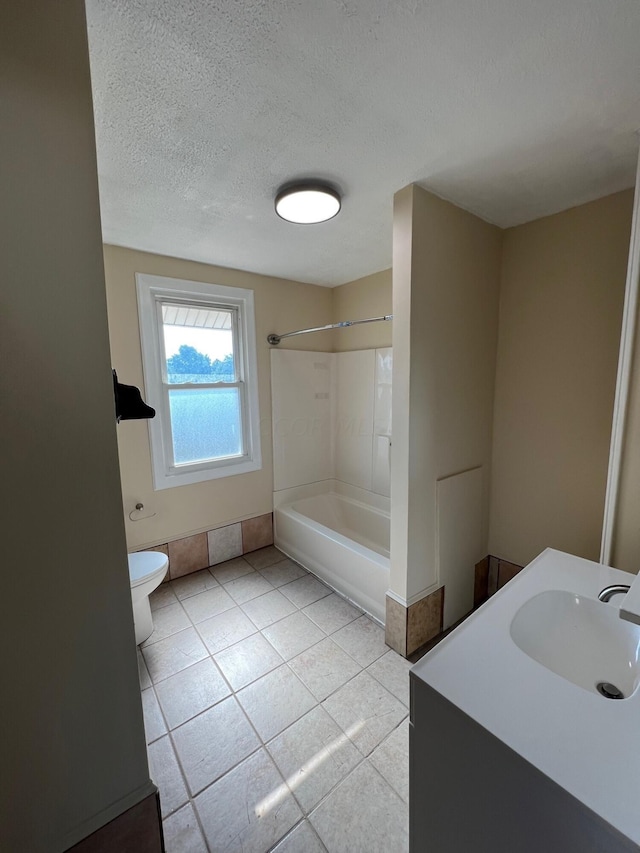 full bathroom with vanity, bathing tub / shower combination, tile patterned floors, toilet, and a textured ceiling