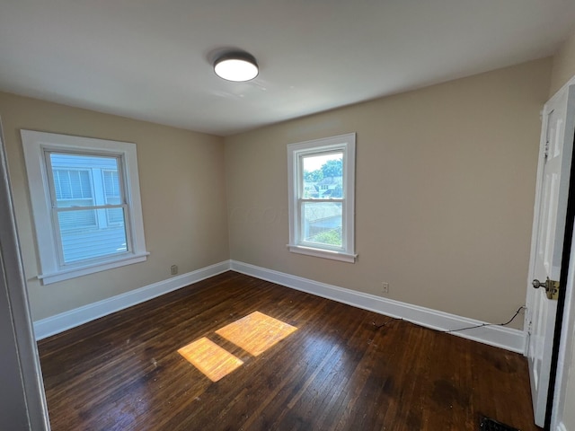 spare room with dark hardwood / wood-style floors