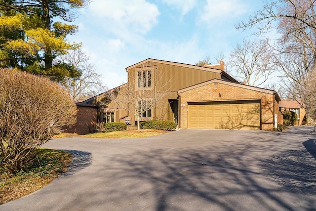 view of front of property with a garage, brick siding, and driveway