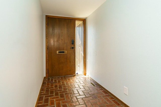 doorway to outside featuring brick floor