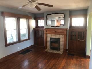 unfurnished living room with a fireplace, ceiling fan, and dark wood-type flooring