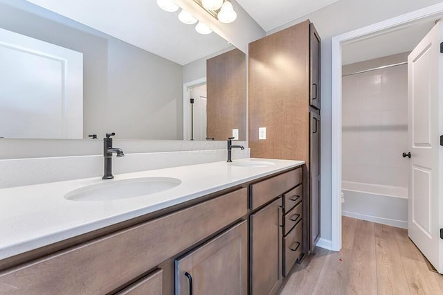 bathroom featuring vanity, hardwood / wood-style floors, and washtub / shower combination