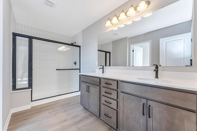 bathroom featuring vanity, wood-type flooring, and an enclosed shower