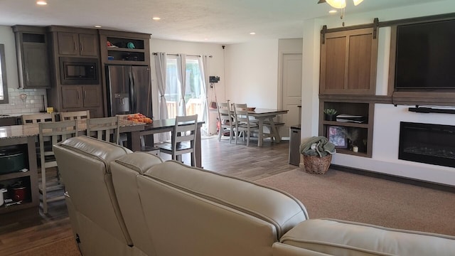 living room with a barn door and dark hardwood / wood-style floors