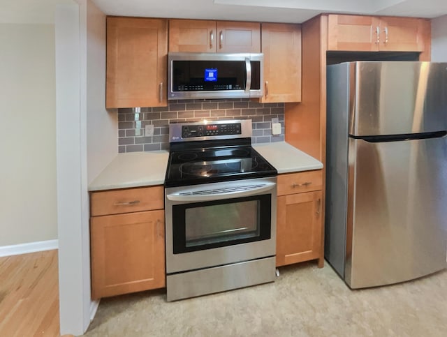 kitchen featuring light hardwood / wood-style floors, backsplash, and appliances with stainless steel finishes