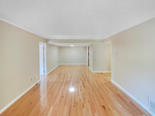 empty room featuring light hardwood / wood-style floors and ornamental molding