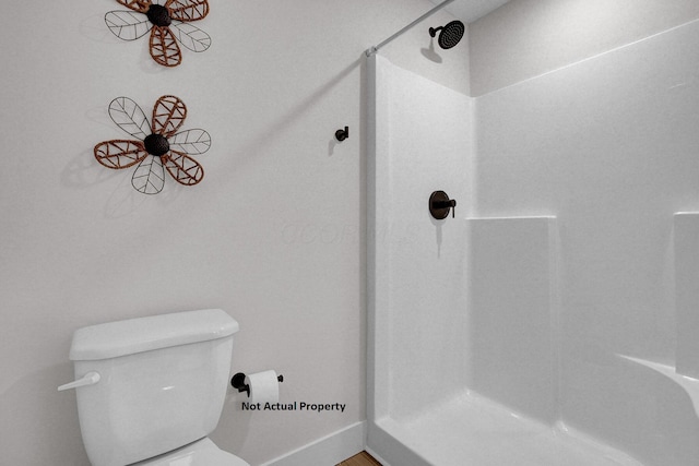 bathroom featuring toilet and walk in shower