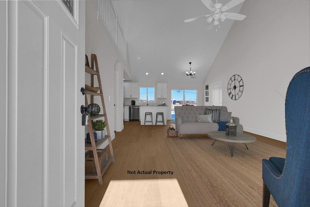 living room featuring high vaulted ceiling, hardwood / wood-style floors, and ceiling fan with notable chandelier