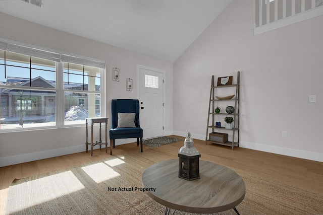 living area with lofted ceiling and hardwood / wood-style flooring