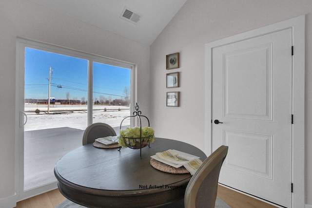 dining area with vaulted ceiling and wood-type flooring