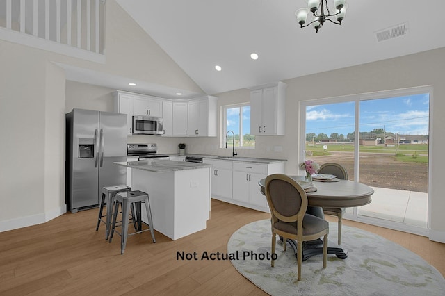 102 Cumberland Meadows Cir, Hebron, OH 43025 - kitchen featuring appliances with stainless steel finishes, a sink, a center island, a chandelier, and high vaulted ceiling