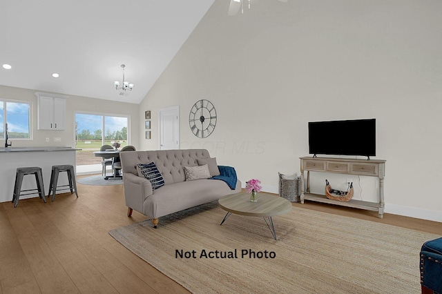 102 Cumberland Meadows Cir, Hebron, OH 43025 - living room featuring a chandelier, light wood-style flooring, recessed lighting, high vaulted ceiling, and baseboards