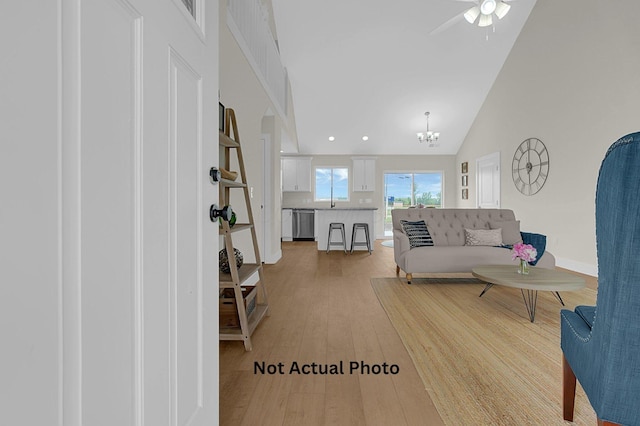 102 Cumberland Meadows Cir, Hebron, OH 43025 - living area with light wood finished floors, ceiling fan, a chandelier, baseboards, and high vaulted ceiling