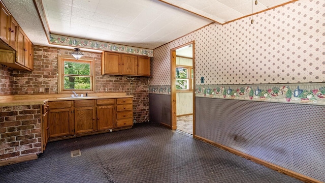 kitchen featuring beamed ceiling, dark carpet, and sink