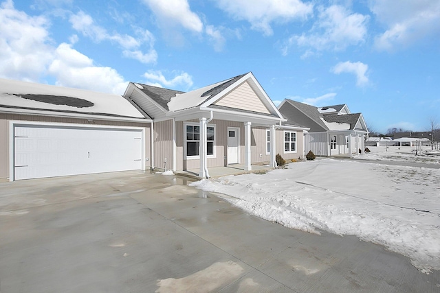 ranch-style home with a garage and covered porch