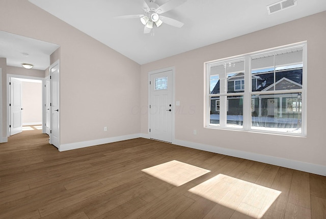 entryway with vaulted ceiling, a wealth of natural light, and hardwood / wood-style floors