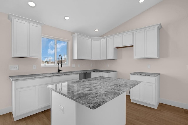 kitchen featuring white cabinets, sink, light hardwood / wood-style floors, and a center island