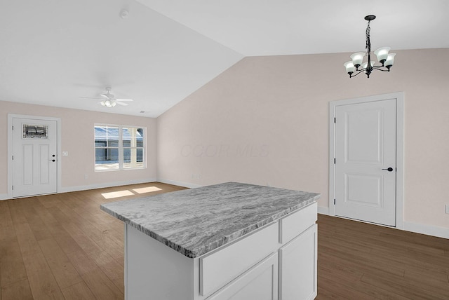 kitchen with dark hardwood / wood-style flooring, hanging light fixtures, vaulted ceiling, ceiling fan with notable chandelier, and white cabinets