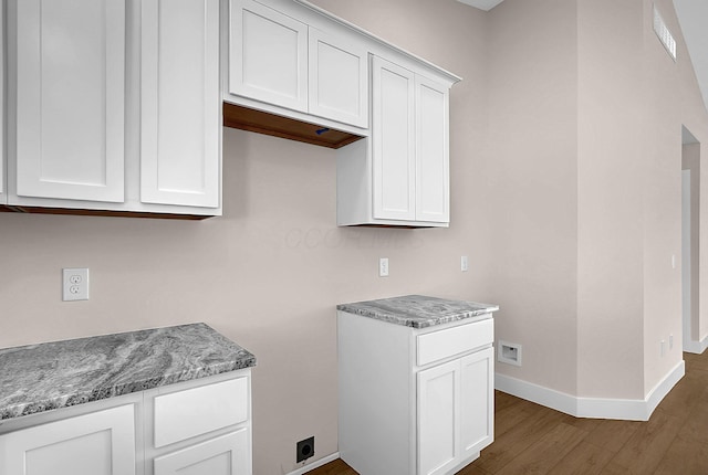 kitchen featuring light stone countertops, white cabinetry, and dark hardwood / wood-style floors