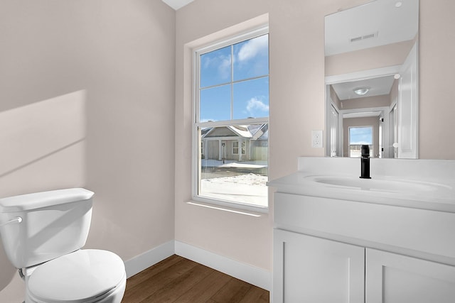 bathroom featuring toilet, hardwood / wood-style flooring, and vanity