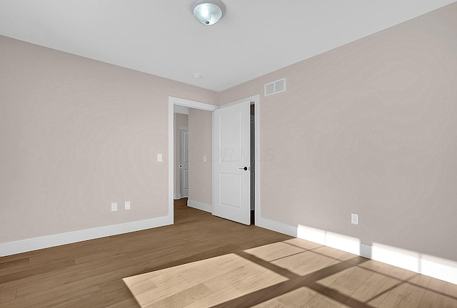 unfurnished room with hardwood / wood-style flooring