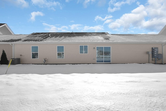 snow covered property featuring central AC unit