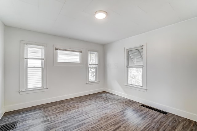 unfurnished room featuring plenty of natural light and dark hardwood / wood-style floors