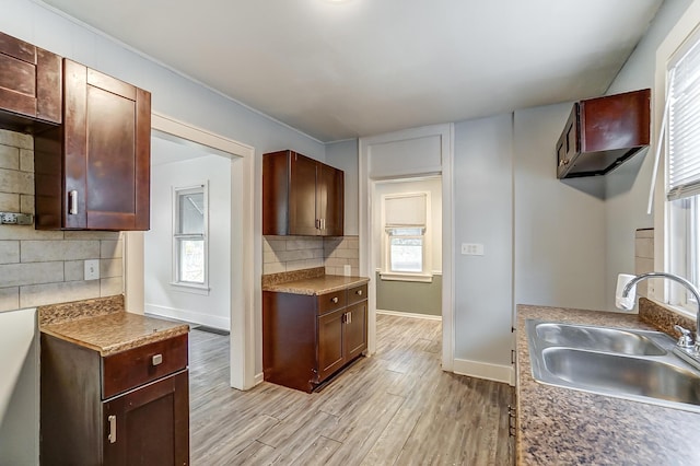 kitchen with backsplash, sink, and light hardwood / wood-style floors